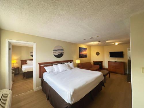 a hotel room with a large bed and a living room at Riviera Inn And Suites 1000 Islands in Gananoque