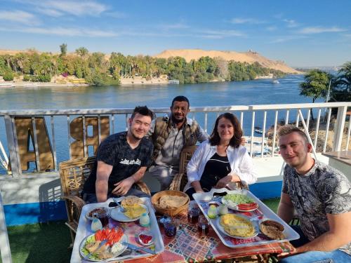 a group of people sitting at a table with food at ABAZIDO Nubian Guest House in Aswan