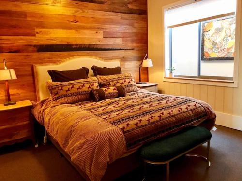 a bedroom with a large bed with a wooden wall at Allview Escape Blackheath in Blackheath