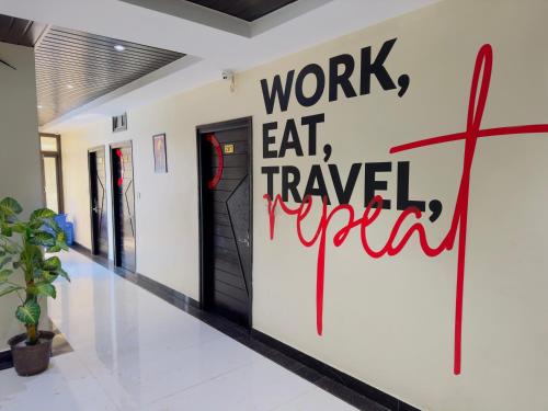 a hallway with a sign that says work eat travel repair at Hotel Grand Bhagwat, Udaipur in Udaipur
