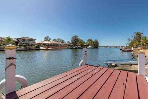 a wooden dock on a river with houses on it at 114 Elizabeth Pde in Forster