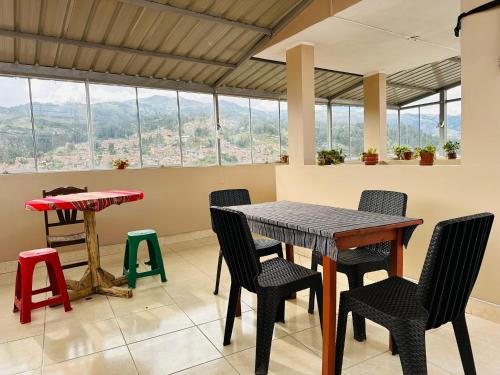 einen Tisch und Stühle in einem Zimmer mit Aussicht in der Unterkunft Yerupaja Mountain Hostel in Huaraz