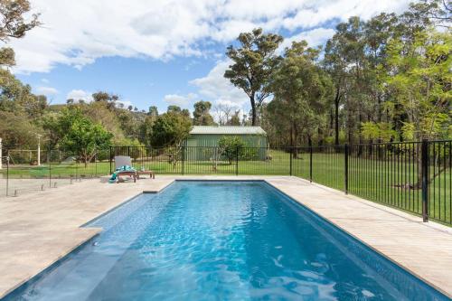 a swimming pool in a yard with a fence at Weetaliba - Country Retreat in Yatte Yattah