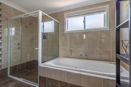 un baño con bañera y ducha de cristal en Salt, en Berrara