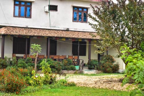 a house with a garden in front of it at Bardiya Eco Safari Homestay in Bhurkīā