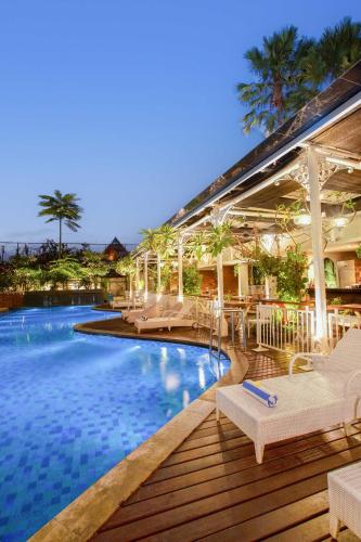 a swimming pool with lounge chairs and a resort at THE 1O1 Yogyakarta Tugu in Yogyakarta