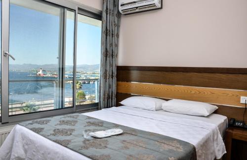 a bedroom with a bed and a large window at Perla Hotel in Dikili