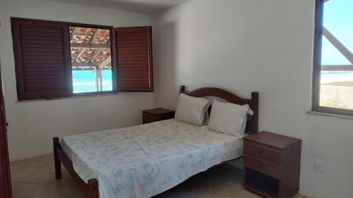 a bedroom with a bed and two windows at Casa de Praia Iguape Ceará Paraíso in Aquiraz