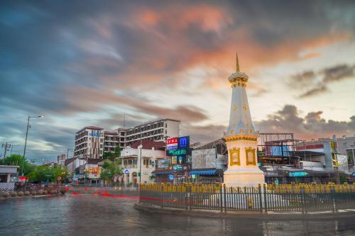 a building with a tower in the middle of a river at THE 1O1 Yogyakarta Tugu in Yogyakarta