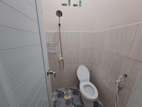 uma casa de banho com um chuveiro e um WC numa cabina em OYO 93695 Guest House Riharti Syariah em Bandar Lampung