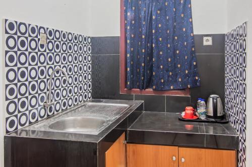 uma cozinha com um lavatório e uma cortina de chuveiro em OYO 93691 Minongga em Jakarta