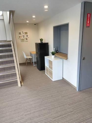 an office with a black refrigerator and a table at FLYCAT INN 伊勢 in Ise