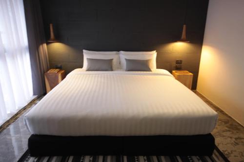a large white bed in a room with a window at La Pause Hatyai in Hat Yai