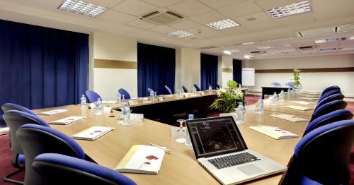 a conference room with a laptop on a long table at Ibis Casablanca Sidi Maarouf in Casablanca