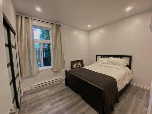 蒙特婁的住宿－4414-Modern 2 BD Gem/ near DT MTL, Canal, Atwater，一间卧室设有一张大床和一个窗户。