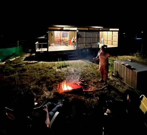 a man standing around a fire in a yard at night at Macchiato in La Pedrera