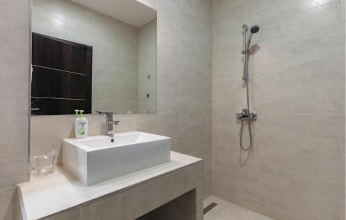La salle de bains est pourvue d'un lavabo blanc et d'une douche. dans l'établissement 1 Bedroom Pet Friendly Apartment In Kastel Kambelovac, à Kaštela