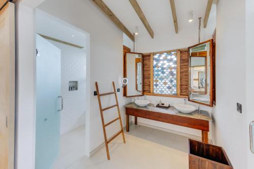 a bathroom with two sinks and a window at Cinnamon Hakuraa Huraa Maldives - All Inclusive in Meemu Atoll