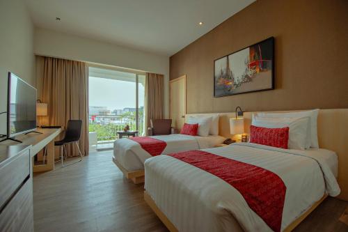 a hotel room with two beds and a television at Grand Zuri BSD City in Serpong