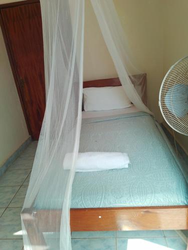 a bed in a room with a mosquito net at Diani Breeze Villas in Diani Beach