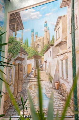 a mural of a street with a castle in the background at Garden Plaza Bukhara in Bukhara