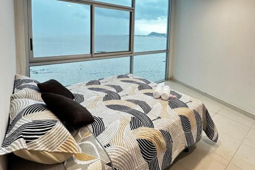 a bed in a room with a view of the ocean at Penthouse de 2 habitaciones con vista al rio y parking in Guayaquil
