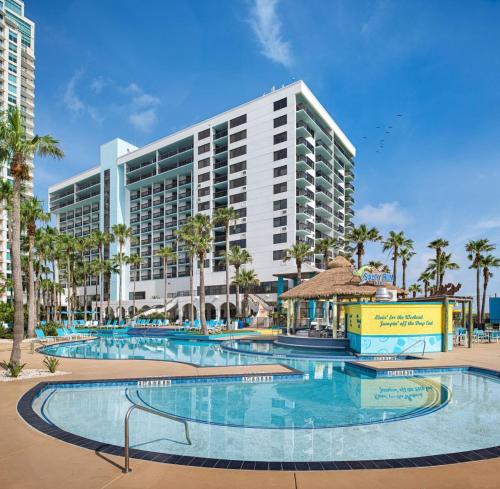 a resort with a large swimming pool in front of a building at Margaritaville Beach Resort South Padre Island in South Padre Island