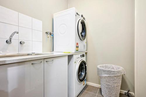 a white laundry room with a washer and dryer at Vibrant Townhouse Hideaway Balcony Bliss & Parking Paradise in Point Cook