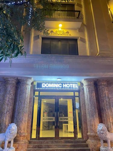 Hòa Ðình的住宿－DOMINIC HOTEL，前面有捐赠酒店标志的建筑
