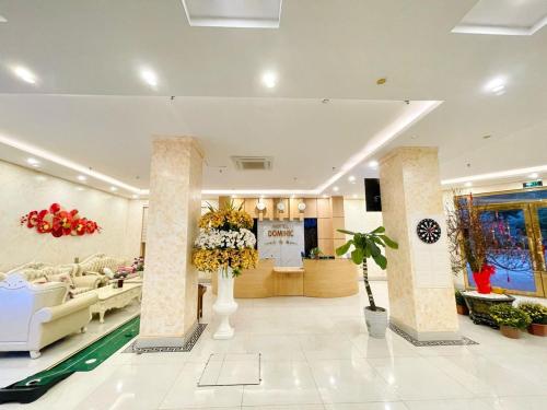 Hòa Ðình的住宿－DOMINIC HOTEL，一间商店里配有沙发和鲜花的大堂