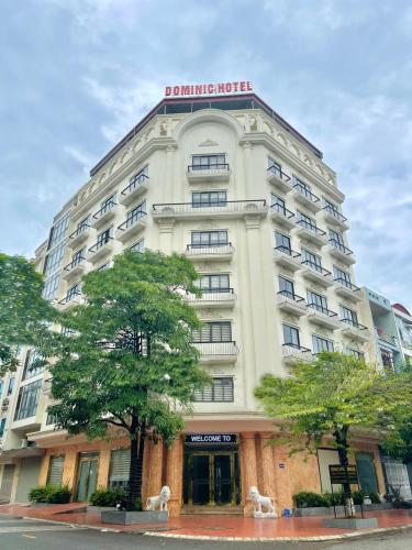 un edificio blanco con un cartel encima en DOMINIC HOTEL en Hòa Ðình