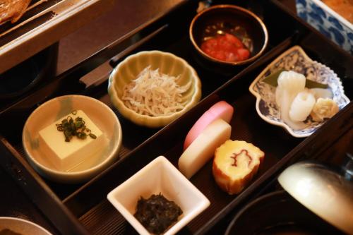 a drawer filled with different types of food in bowls at 湘南江の島　御料理旅館　恵比寿屋 in Fujisawa