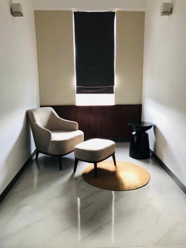 - un salon avec une chaise et un tabouret dans l'établissement Royce Residence, à Matara
