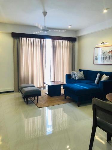 - un salon avec un canapé bleu et une table dans l'établissement Royce Residence, à Matara