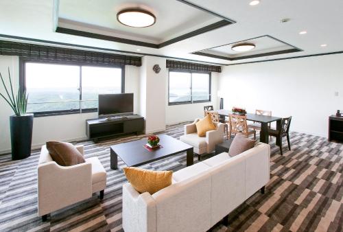 a living room with two couches and a table at Grand Mercure Ise-shima Resort & Spa in Shima
