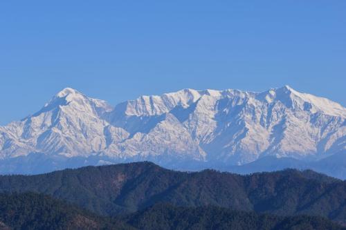 a mountain range with snow capped mountains in the background at Kasar Himalaya Holiday Resort, Binsar Rd in Almora