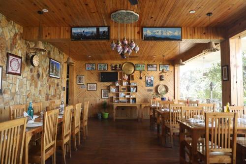 a restaurant with wooden walls and tables and chairs at Kasar Himalaya Holiday Resort, Binsar Rd in Almora