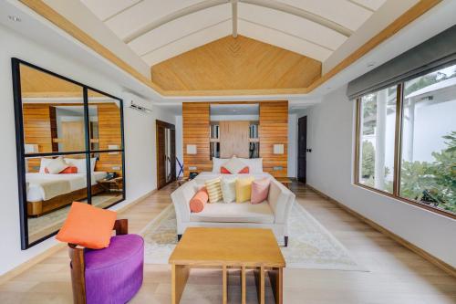 een woonkamer met een bank en een tafel bij Cinnamon Hakuraa Huraa Maldives - All Inclusive in Meemu Atoll