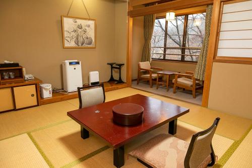 a living room with a wooden table and chairs at 静かなお宿加賀美 in Shimojo mura