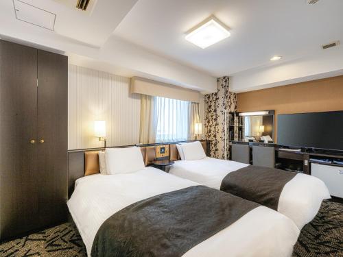 Postel nebo postele na pokoji v ubytování APA Hotel Niigata Tsubamesanjo Ekimae