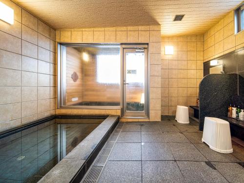 un bagno vuoto con finestra e serbatoio d'acqua di APA Hotel Niigata Tsubame-Sanjo Ekimae a Tsubame