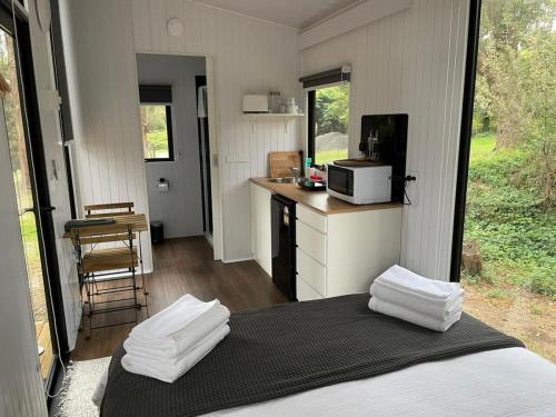 a room with a bed and a kitchen with a microwave at Longmore Estate in Daylesford