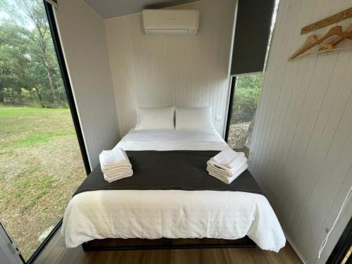 Longmore Estate في ديلسفورد: سرير في غرفة صغيرة مع نافذة كبيرة