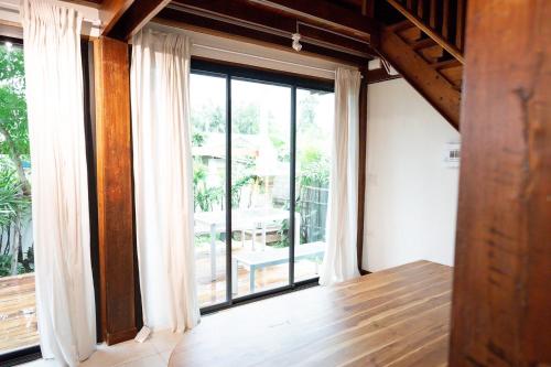a room with a large window with a view of a patio at Baan Inn in Chiang Dao