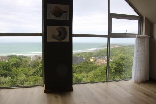 a room with a large window with a view of the ocean at Ungabona in East London