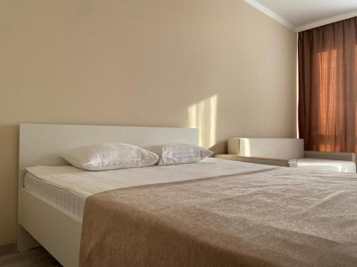 um quarto com uma cama com duas almofadas em ЖК Sati Club House em Prigorodnyy