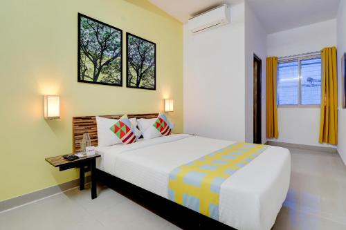 a bedroom with a bed and a desk and two windows at OYO Home Exotic Stay Bsk 3rd Stage in Bangalore
