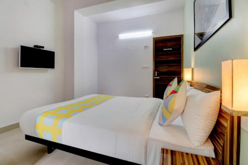 a bedroom with a bed and a tv on a wall at OYO Home Exotic Stay Bsk 3rd Stage in Bangalore