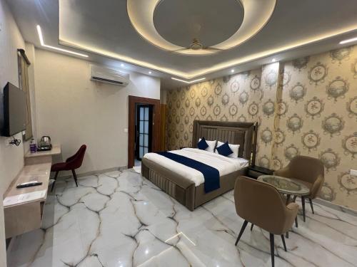 a hotel room with a bed and a table and chairs at Crescent Inn in Greater Noida