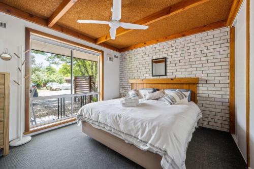 a bedroom with a bed and a large window at Kalamunda 6 - On the Rail Trail in Bright